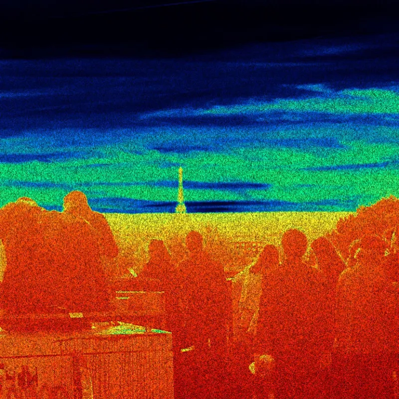 Thermal camera view of a crowd with the Eiffel Tower visible in the distance