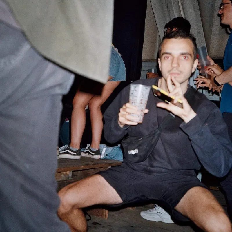 A man squatting at a party