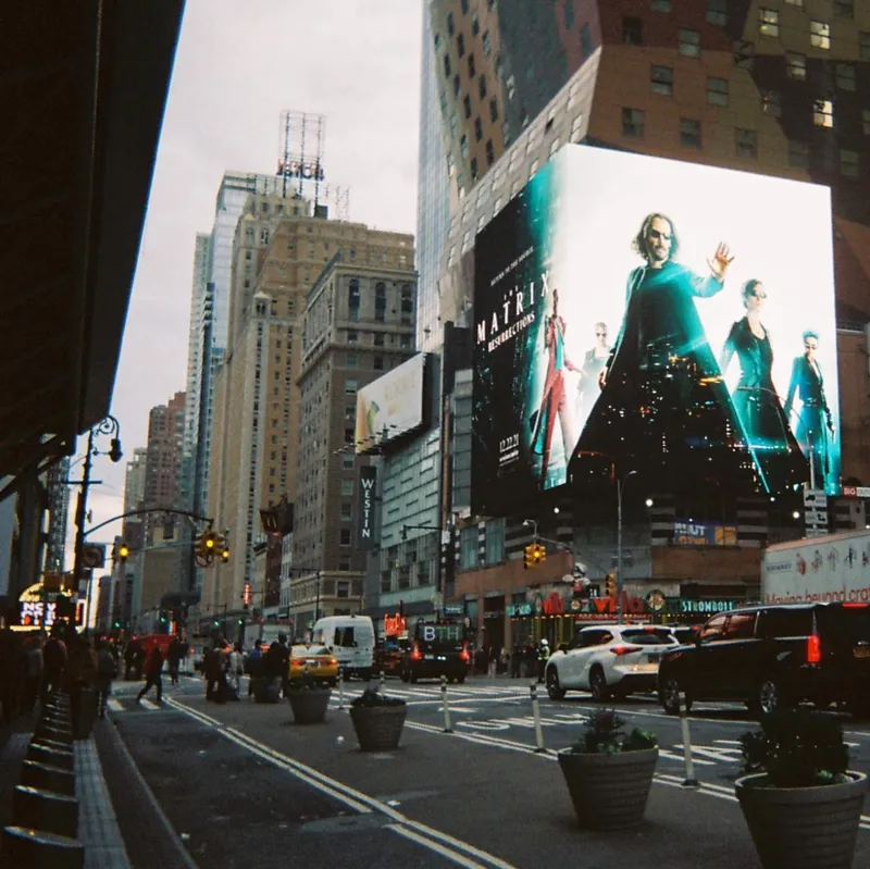 Times Square street view with a large Matrix Resurrections billboard and city traffic