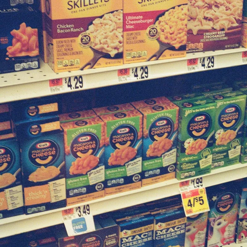 Grocery store shelves stocked with Kraft macaroni and cheese boxes