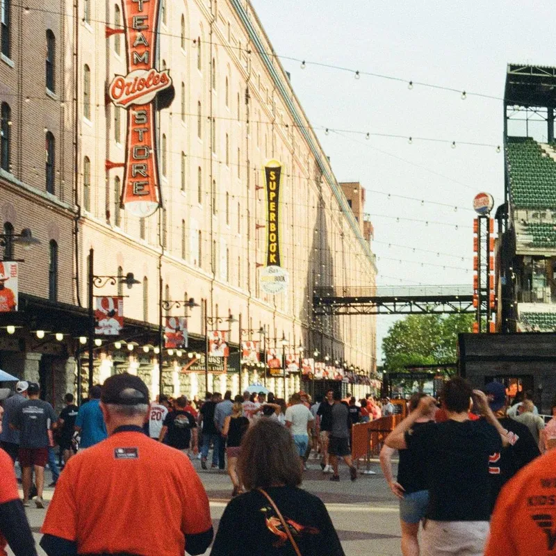 Crowds of Orioles fans walking along Camden Yards at golden hour