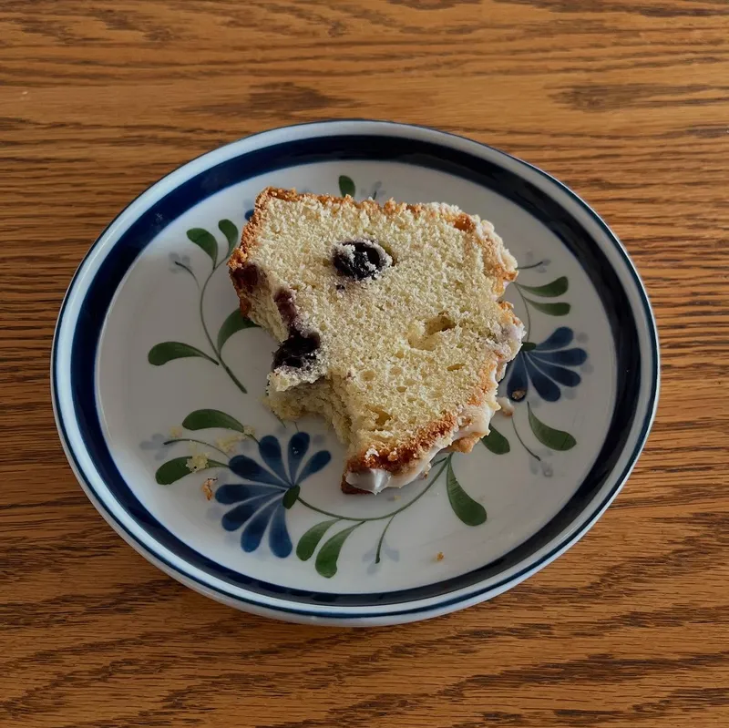 A slice of blueberry pound cake on a floral plate