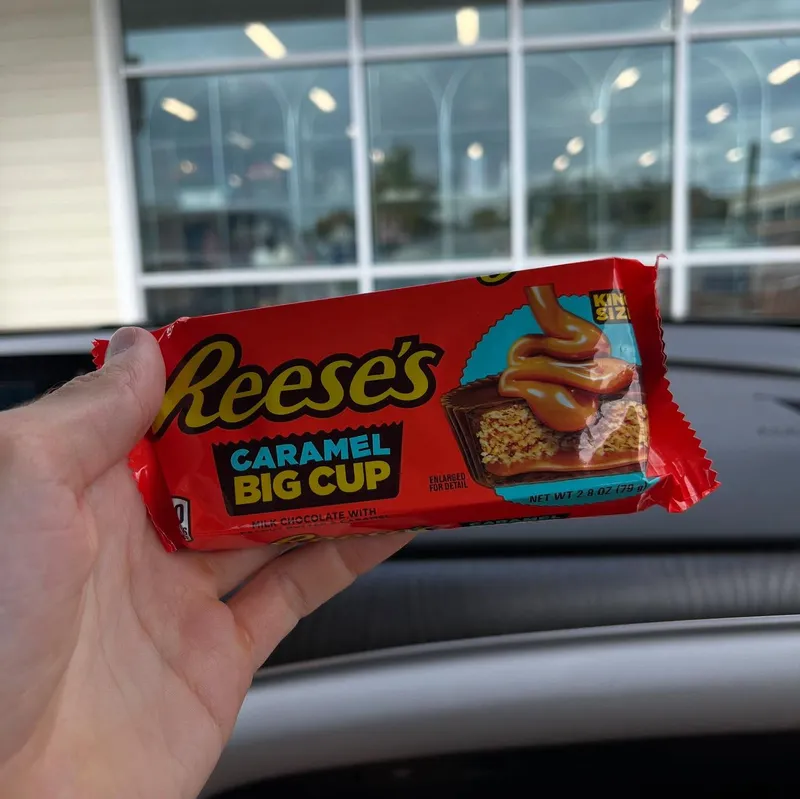 A hand holding a Reese's Caramel Big Cup